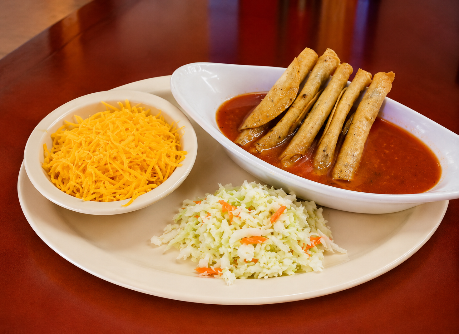 Ahogadas plate with rolled flautas in red sauce, cheese and slaw